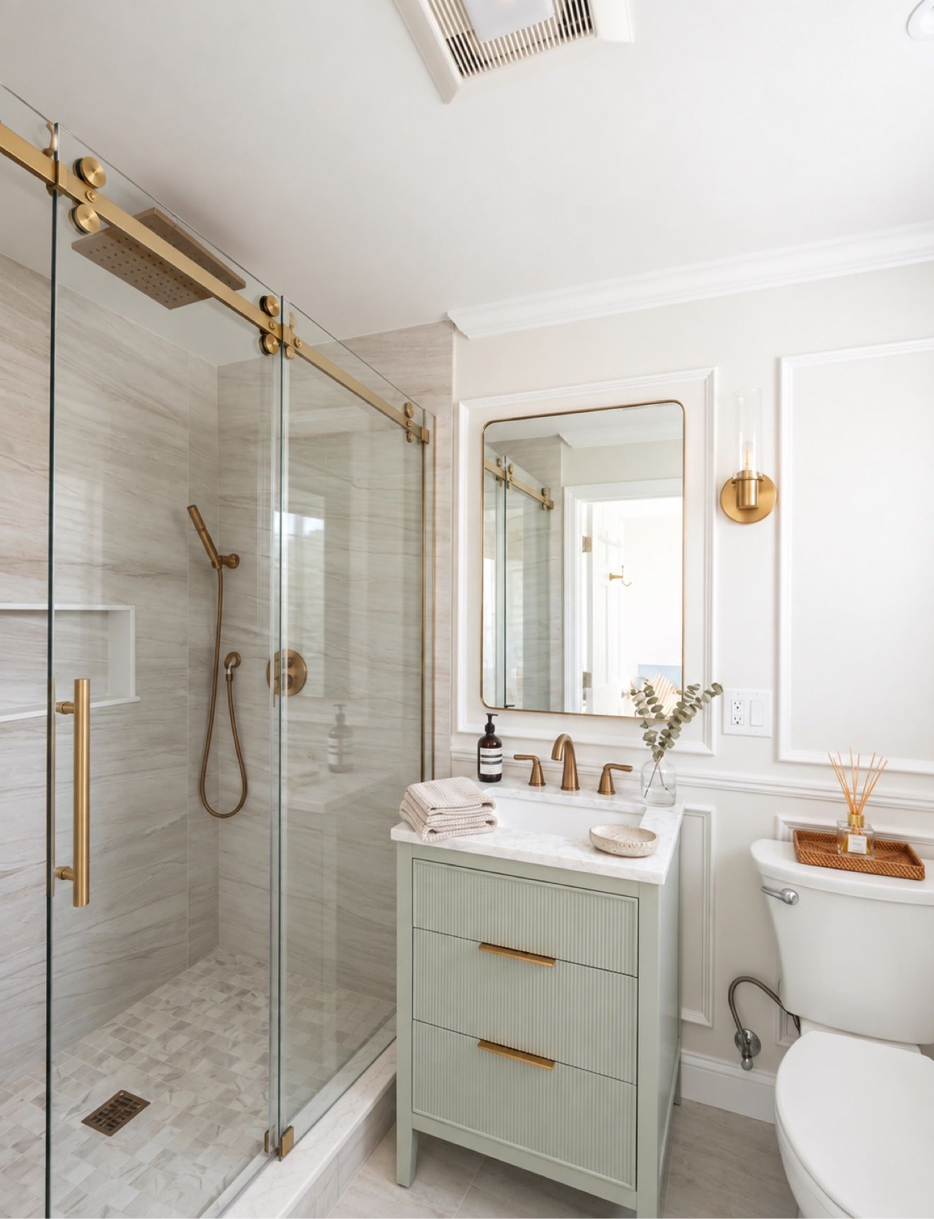 Renovated bathroom with glass walk-in shower, brass fixtures, and sage vanity